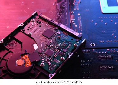 Computer Hard disk drives HDD , SSD on circuit board ,motherboard background. Close-up. With red-blue lighting