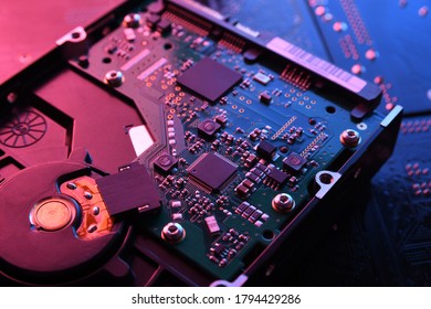 Computer Hard disk drives HDD , SSD on circuit board ,motherboard background. Close-up. With red-blue lighting