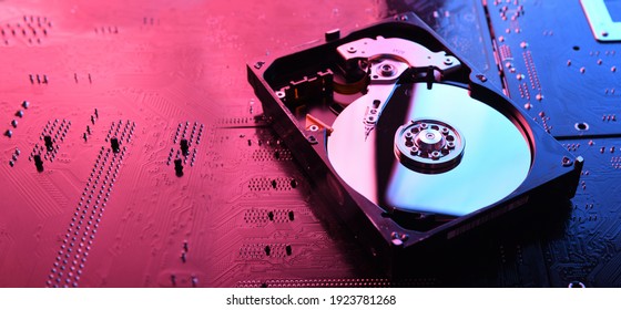 Computer Hard disk drives HDD , SSD on circuit board ,motherboard background. Close-up. With red-blue lighting