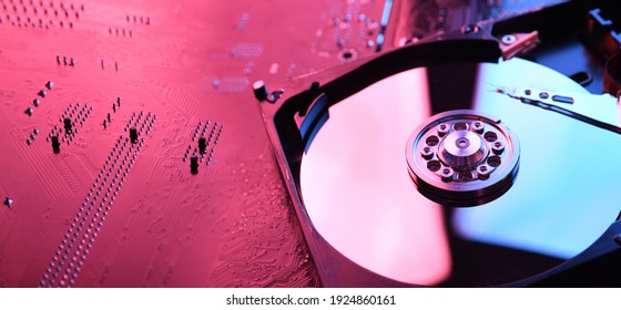 Computer Hard disk drives HDD , SSD on circuit board ,motherboard background. Close-up. With red-blue lighting.