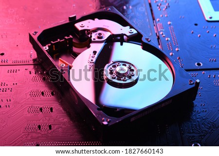 Computer Hard disk drives HDD , SSD on circuit board ,motherboard background. Close-up. With red-blue lighting