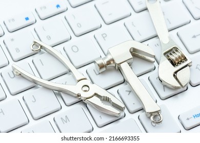 Computer Hardware Service And Maintenance Concept : Crest Hammer, An Adjustable Wrench, A Needle-nose Plier On A Computer Keyboard, Depicts Repairing, Software Updating Or Changing To A Newer Version.