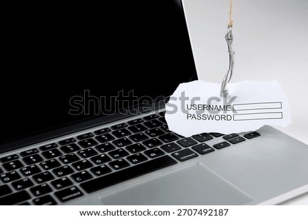 Computer keyboard with a baited hook displaying a username and password form highlighting cybersecurity risks and phishing dangers