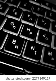 Computer keyboard black and white backlit close up.