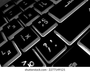 Computer keyboard black and white backlit close up.