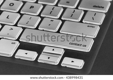 The computer keyboard button written word contact us .