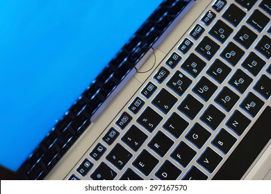 Computer keyboard close-up with blue screen