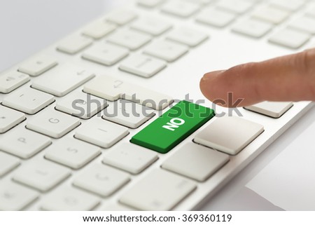Computer Keyboard Concept: Hand pushing green NO keyboard button