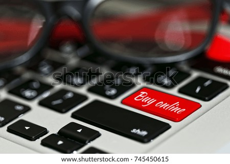 Computer keyboard with e-commerce conceptual tagline and red color accent. Online payments and tranaction idea, e-commerce era metaphor. Close-up capture, selective focus.
