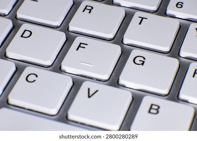 Computer keyboard keys arranged in a close-up view, showcasing white keycaps with black letters. The image focuses on the middle section of the keyboard, highlighting letters D, F, G, C, V, B, R, T am