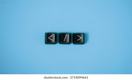 Computer keyboard keys with arrow brackets and slash symbols on blue background. Concept of coding, web development, software programming and html syntax.