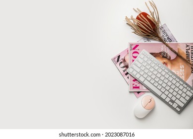 Computer keyboard, mouse and magazines on white background