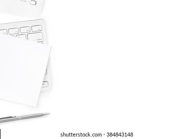 Computer keyboard, mouse, notebook and pen are on isolated white background, top view with copy space.