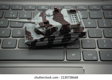 Computer keyboard with tanks on it. An allusion to cyber warfare.concept of cyber attacks. - Shutterstock ID 2130738668