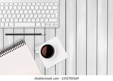 Computer keyboard at workplace and cup