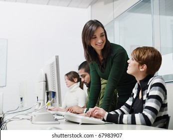 Computer Lab With Caucasian Female Teacher Helping Student. Horizontal Shape, Side View, Waist Up, Copy Space