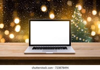 Computer laptop with blank screen on  snowfall in christmas tree.winter backgrounds