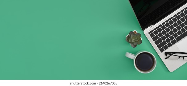 Computer Laptop, Coffee Cup And Succulent Plant On Green Background With Copy Space For Text. Flay Lay.