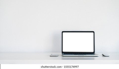 Computer laptop on the white table with White screen and copy-spcae for Design background.