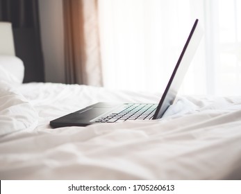 computer laptop open on the bed in the morning, concept of work from home or stay on home