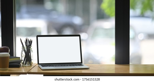 Computer Laptop Is Putting On A Counter Bar Surrounded By Pencil Holder And Equipment.