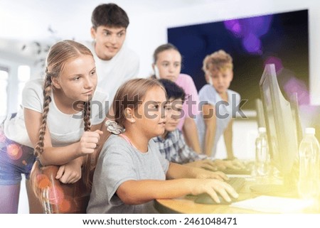 Computer lesson in classroom - classmates solve problems on the computer together
