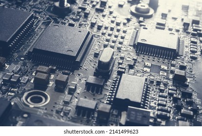Computer Microchips on Electronic circuit board. Technology microelectronics concept background. Macro shot, selective focus, extremely shallow DOF. Noises and large grain - stylization under film.