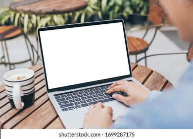 computer mockup image blank screen with white background for advertising text,hand woman using laptop contact business search information on desk at coffee shop.marketing and creative design