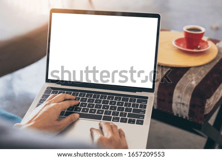 computer mockup image blank screen with white background for advertising text,hand woman using laptop contact business search information on desk at coffee shop.marketing and creative design