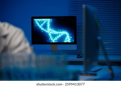 Computer monitor displaying rotating dna double helix animation in dark laboratory lit with blue light at night, concept of genetic engineering and biotechnology