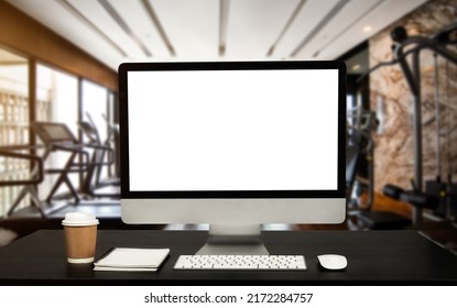 Computer Monitor, Keyboard, coffee cup and Mouse with Blank or White Screen Isolated is on the work table at the fitness gym in morning light - Shutterstock ID 2172284757