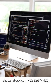 Computer monitor with programming code at programmer's workplace in office