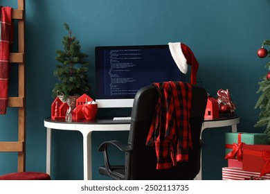 Computer monitor with Santa hat, cocoa and Christmas tree on programmer's desk in office - Powered by Shutterstock