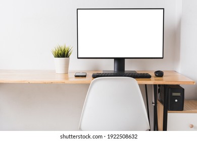 Computer Monitor With White Blank Screen On The Business Desk With Wireless Mouse, Keyboard At Home Office Over White Wall Background, Photo Of Equipment Contemporary Workspace