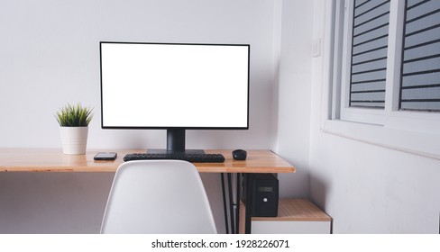 Computer Monitor With White Blank Screen On The Business Desk With Wireless Mouse, Keyboard At Home Office Over White Wall Background, Photo Of Equipment Contemporary Workspace