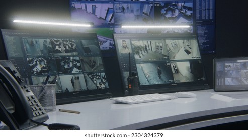 Computer monitors and tablet showing video footage of surveillance cameras with AI facial recognition system. Big digital screen on the wall on background. Modern security control center. Timelapse. - Shutterstock ID 2304324379
