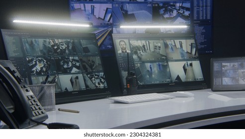 Computer monitors and tablet showing video footage of surveillance cameras with AI facial recognition system. Big digital screen on the wall on background. Modern security control center. Timelapse. - Shutterstock ID 2304324381