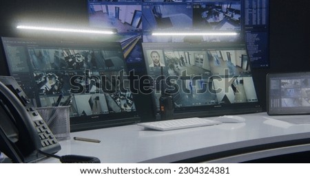 Computer monitors and tablet showing video footage of surveillance cameras with AI facial recognition system. Big digital screen on the wall on background. Modern security control center. Timelapse.
