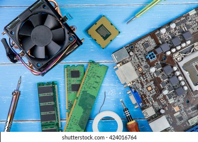 Computer Motherboard, Computer Parts, Hard Disk, Ram And Equipment Repair On The Blue Wooden Background.