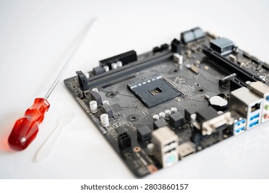 Computer motherboard with processor socket and screwdriver, representing PC repair, hardware upgrade, electronics maintenance, DIY computer assembly, digital technology and engineering on a clean background.