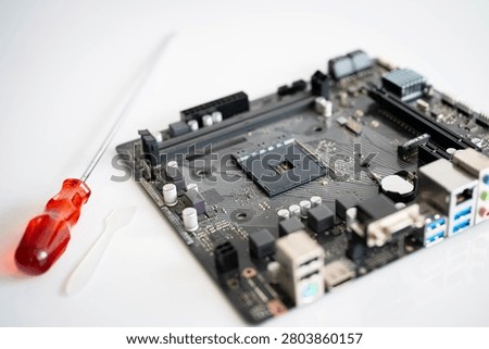 Computer motherboard with processor socket and screwdriver, representing PC repair, hardware upgrade, electronics maintenance, DIY computer assembly, digital technology and engineering on a clean background.