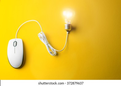 Computer mouse and bulb on a yellow background - Shutterstock ID 372879637