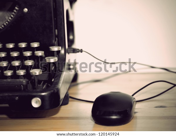 Computer mouse connected to vintage typewriter