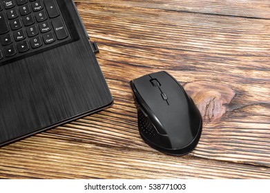 Computer mouse with laptop on the  table.