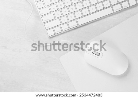 Computer mouse with mousepad and keyboard on light wooden table, flat lay