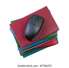 Computer mouse on stack of books. Isolated white background.