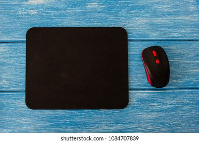 computer mouse pad and mouse on a blue wooden background