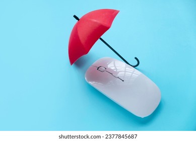 Computer and network security concept. Red umbrella over a computer mouse.