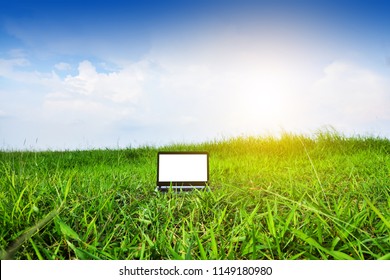 computer notebook in green field under blue sky.Blogger Sky and Clouds