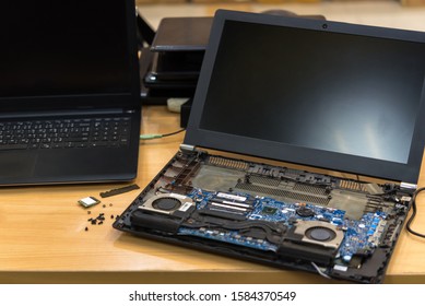 Computer Notebook (laptop) Repairman Or Technician Checking A Laptop Component In Disassembled Laptop Fix And Repair Problem At Computer Shop